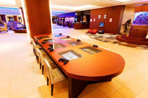 a long wooden table in a lobby with chairs at Sheraton Grande Tokyo Bay Hotel in Urayasu