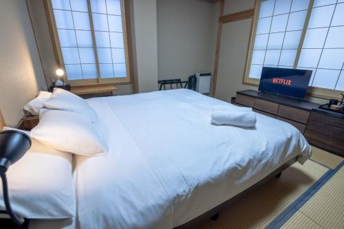 a hospital room with a bed and a television at Welcome Nozawa in Nozawa Onsen