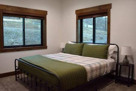 a bedroom with a bed and two windows at Trails End Lodge in Irwin
