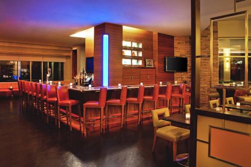 a bar in a restaurant with red chairs at The Westin Washington Dulles Airport in Herndon