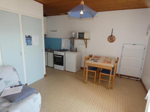 une petite cuisine avec une table et une table et des chaises dans l'établissement Maison en forêt à 10 min de la plage, animaux admis, parking - FR-1-540-299, à Notre-Dame-de-Monts