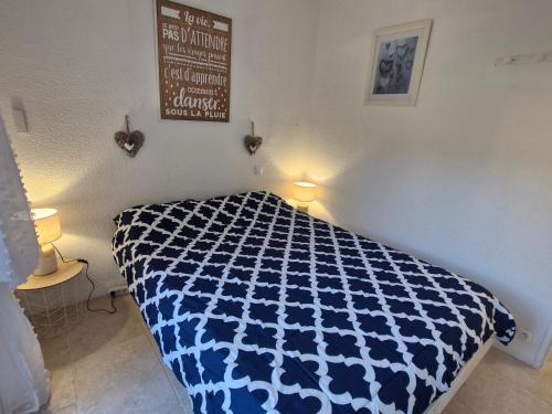 - une chambre avec une couette bleue et blanche sur un lit dans l'établissement Appartement 3 pièces climatisé avec piscine et parking proche plage à Sainte-Maxime - FR-1-780-87, à Sainte-Maxime