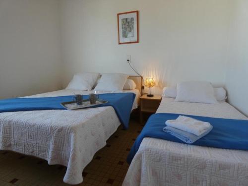 Cette chambre comprend 2 lits avec des draps bleus et blancs. dans l'établissement Appartement 1 ch, 5 pers, forêt, animaux acceptés, parking - FR-1-540-301, à Notre-Dame-de-Monts