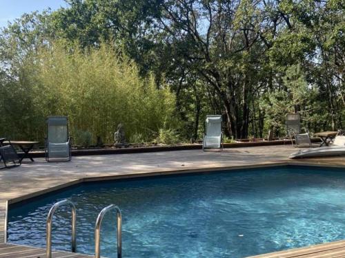 - une piscine avec des chaises, une table et des arbres dans l'établissement Maison bois avec piscine privée et Wifi, animaux admis - FR-1-616-447, à Aubas