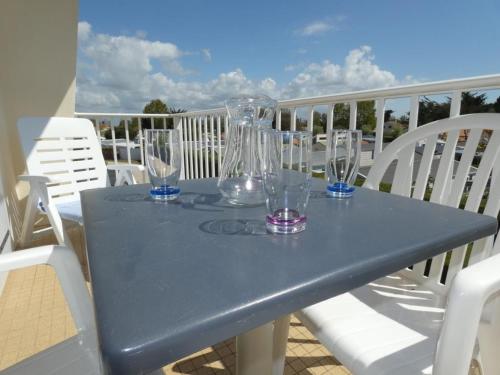 une table bleue avec des verres au-dessus d'un balcon dans l'établissement Appartement 39m² pour 5 pers, proche plage, parking, animaux admis - FR-1-540-296, à Notre-Dame-de-Monts
