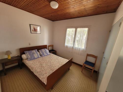 une chambre avec un lit, une chaise et une fenêtre dans l'établissement Maison mitoyenne proche plage, animaux admis, parking - FR-1-540-300, à Notre-Dame-de-Monts