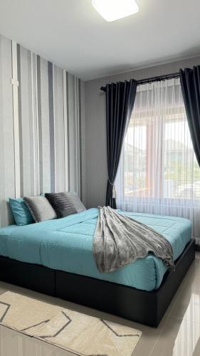 a bed in a bedroom with a window at Vela House Songkhla in Songkhla