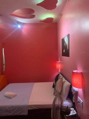 a bedroom with red walls and a bed with two lamps at KS Tình Nhân Sach Hotel in Ho Chi Minh City