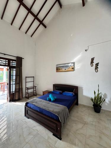 a bedroom with a blue bed in a white room at Grand Royal Villa Negombo in Negombo