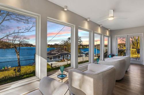 a living room with chairs and large windows at Hilltop Lakehouse - Free Kayaks Deck PLX in Akron