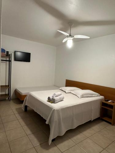 a bedroom with a bed with a ceiling fan at Suites Centro Torres in Torres