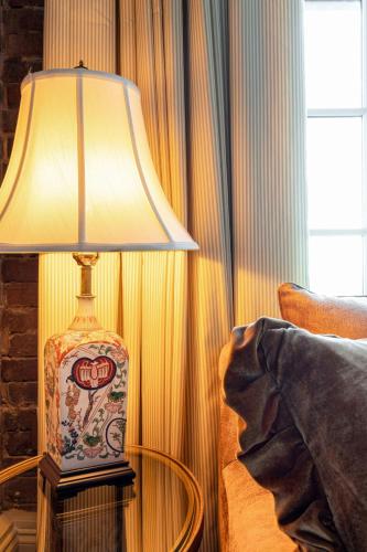 a lamp sitting on a table next to a bed at Hotel Cleo, Knoxville Downtown, a Tribute Portfolio Hotel in Knoxville