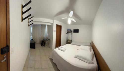 a bedroom with a bed and a ceiling fan at Suites Centro Torres in Torres