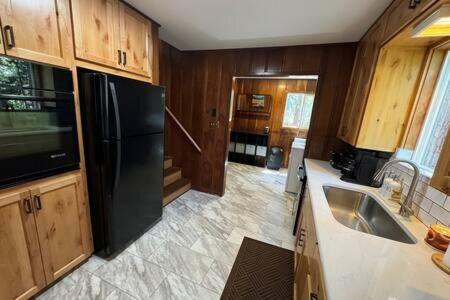 Una cocina con un refrigerador negro y un fregadero. en Spacious Tahoe Hot Tub and Beach, en Kings Beach