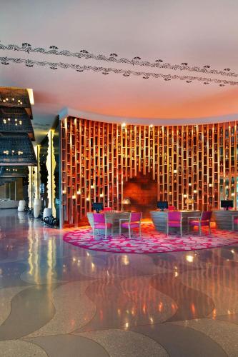 a hotel lobby with pink chairs in front of a building at W Bali - Seminyak in Seminyak