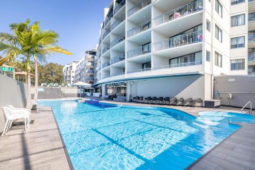 a swimming pool in front of a building at The Landmark unit 405 Resort style, spectacular water views, lift, linen, pool, games room, port-a-cot and highchair. in Nelson Bay
