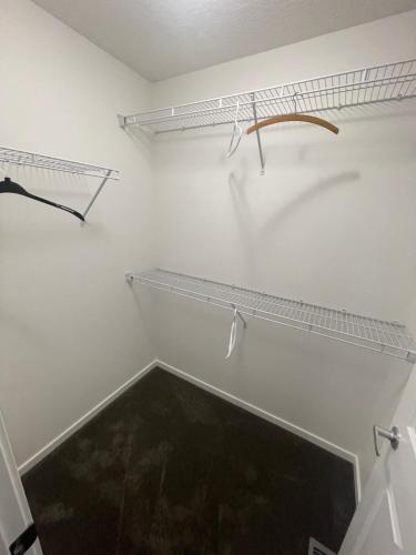 a walk in closet with two shelves on the wall at DLush room in Calgary