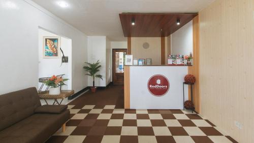 a waiting room with a couch and a counter at RedDoorz at Socor Pension House Iligan City in Iligan City