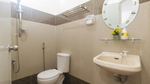 a bathroom with a toilet and a sink and a mirror at RedDoorz at Socor Pension House Iligan City in Iligan City