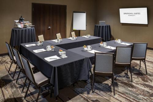 a conference room with three tables and chairs and a screen at SpringHill Suites by Marriott Springdale Zion National Park in Springdale