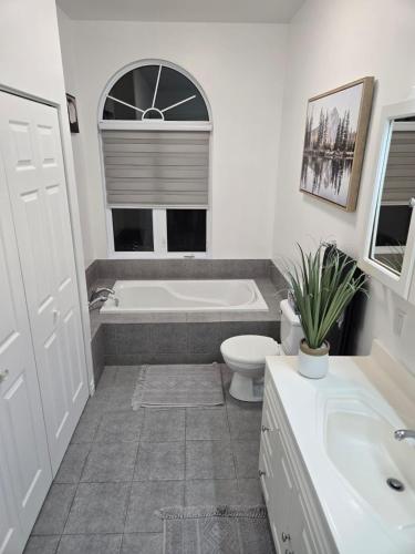 a bathroom with a tub and a toilet and a sink at Villa Des Petits Bonheurs in Lac-Simon