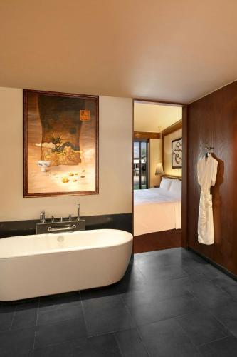 a bathroom with a bath tub and a bedroom at The St. Regis Lhasa Resort in Lhasa