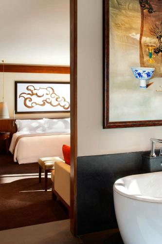 a bathroom with a bed and a tub and a sink at The St. Regis Lhasa Resort in Lhasa