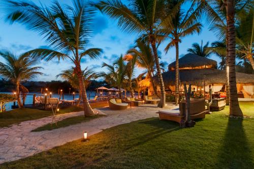 a resort with palm trees and a beach at night at Eden Roc Cap Cana in Punta Cana