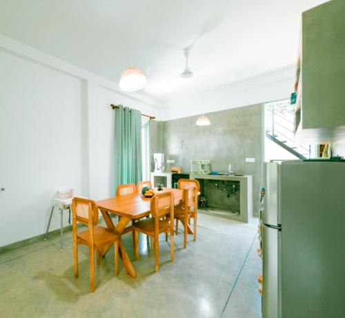 a kitchen with a table and chairs and a refrigerator at Villa Ciana- Private apartment in Unawatuna
