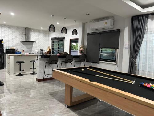 a living room with a pool table and a kitchen at Jazzy Pool Villa Hatyai in Hat Yai