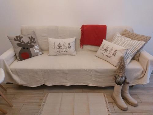 a white couch with christmas pillows on it at Három Testvér Apartman in Siófok