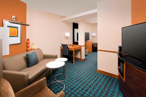 a hotel room with a couch and a flat screen tv at Fairfield Inn & Suites-Washington DC in Washington, D.C.