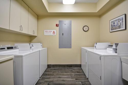 a laundry room with white washers and a clock on the wall at TownePlace Suites Sioux Falls in Sioux Falls