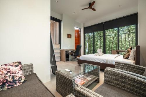 a bedroom with a bed and a living room at V158 9BR Tennis On prestigious Phuket Country Club in Ban Thung Thong