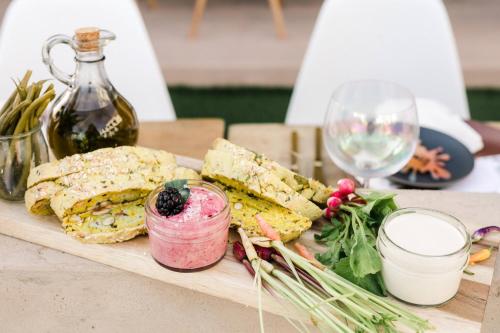 a plate of food on a table with wine glasses at Moxy Santa Barbara in Santa Barbara