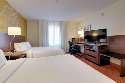 a hotel room with two beds and a desk with a television at Fairfield Inn and Suites by Marriott Potomac Mills Woodbridge in Woodbridge