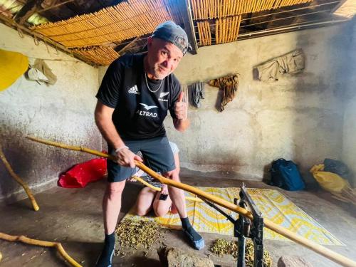 a man is holding a large stick at Palabaddala Tea and Eco Lodge in Ratnapura