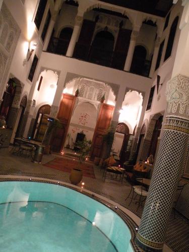 a large swimming pool in a building at Riad Jamaï in Fès
