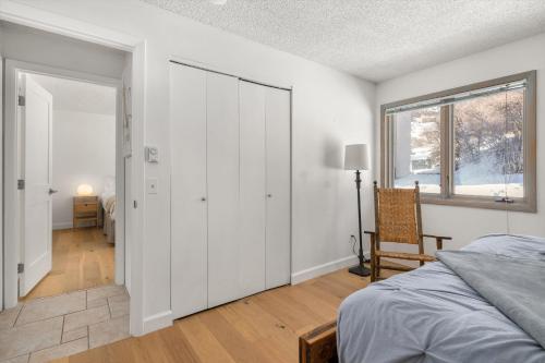 ein Schlafzimmer mit weißen Wänden, einem Bett und einem Fenster in der Unterkunft Upper Woodbridge 29C condo in Snowmass Village
