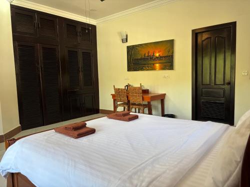 a bedroom with a white bed with two wooden blocks on it at Lily Pad Boutique Hotel in Siem Reap