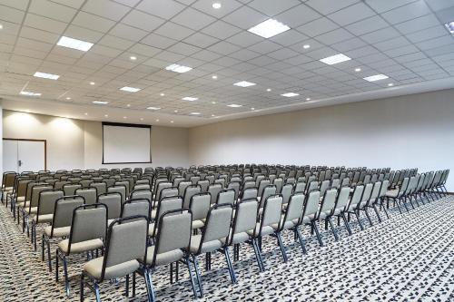 an empty room with chairs and a projection screen at Sheraton Vitoria in Vitória