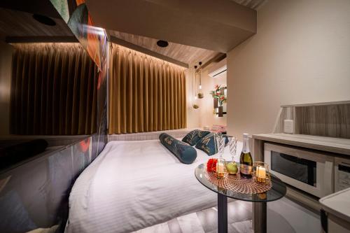 a small bedroom with a bed and a table at Hotel CARA 大人専用Adult only hotel in Tokyo