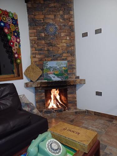 a fireplace in a living room with a fire at HOSPEDAJE LA LOMITA, Cabañas in Monguí