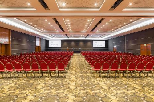 an empty auditorium with red chairs and a stage at Sheraton Asuncion Hotel in Asuncion