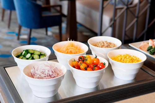 a tray with white bowls of vegetables on a table at Yokohama Bay Sheraton Hotel and Towers in Yokohama