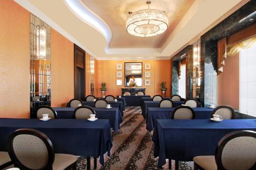 a room with blue tables and chairs and a chandelier at Yokohama Bay Sheraton Hotel and Towers in Yokohama
