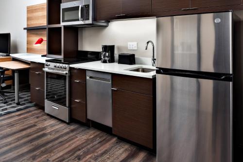 a kitchen with a stainless steel refrigerator and a sink at TownePlace Suites by Marriott Loveland Fort Collins in Loveland