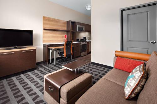 a living room with a couch and a desk with a computer at TownePlace Suites by Marriott Loveland Fort Collins in Loveland