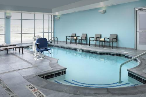 a large swimming pool with chairs in a building at SpringHill Suites by Marriott Loveland Fort Collins/Windsor in Windsor