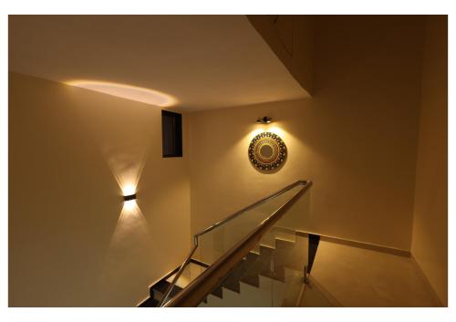 a staircase with a light and a clock on the wall at Katha Villa 63 - Luxury Holiday Home in Karjat